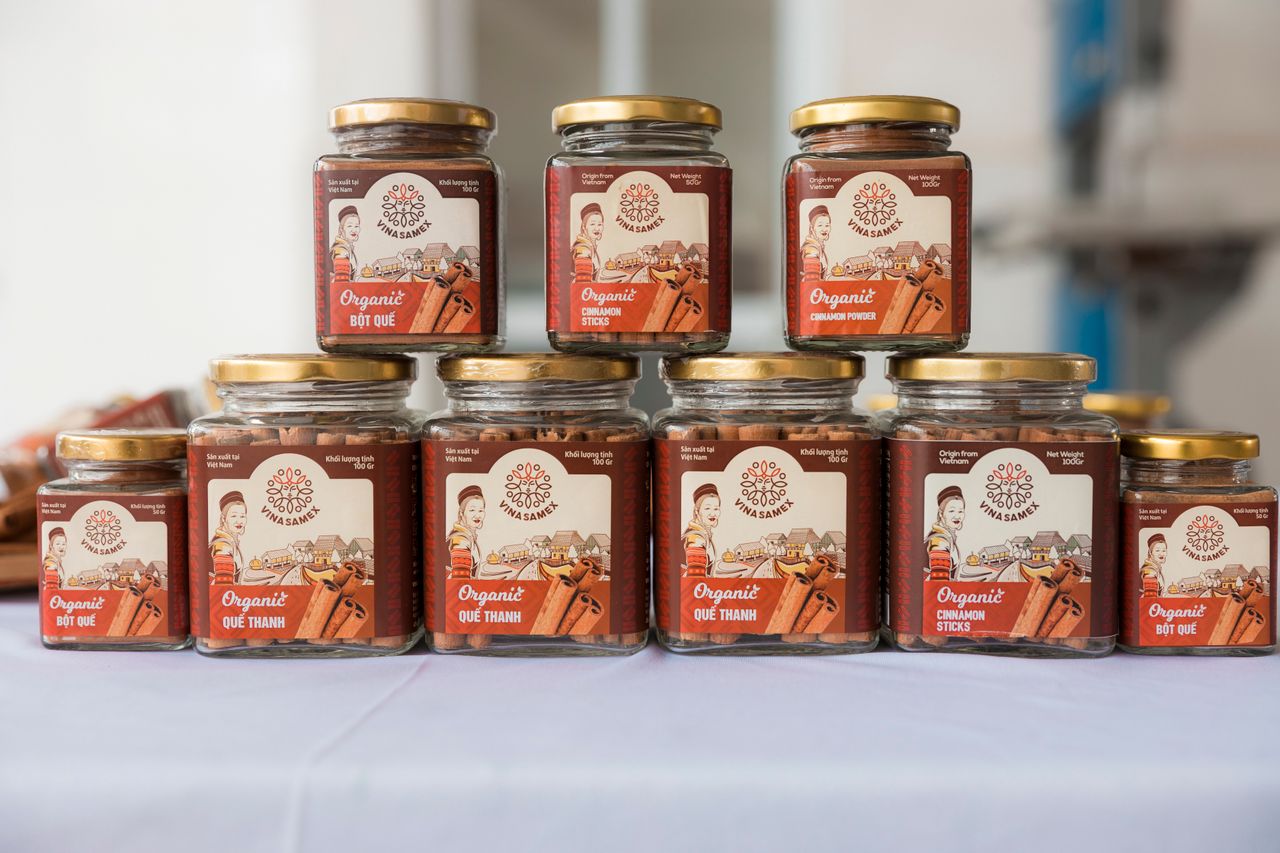 Organized display of organic cinnamon jars in glass containers on a table.